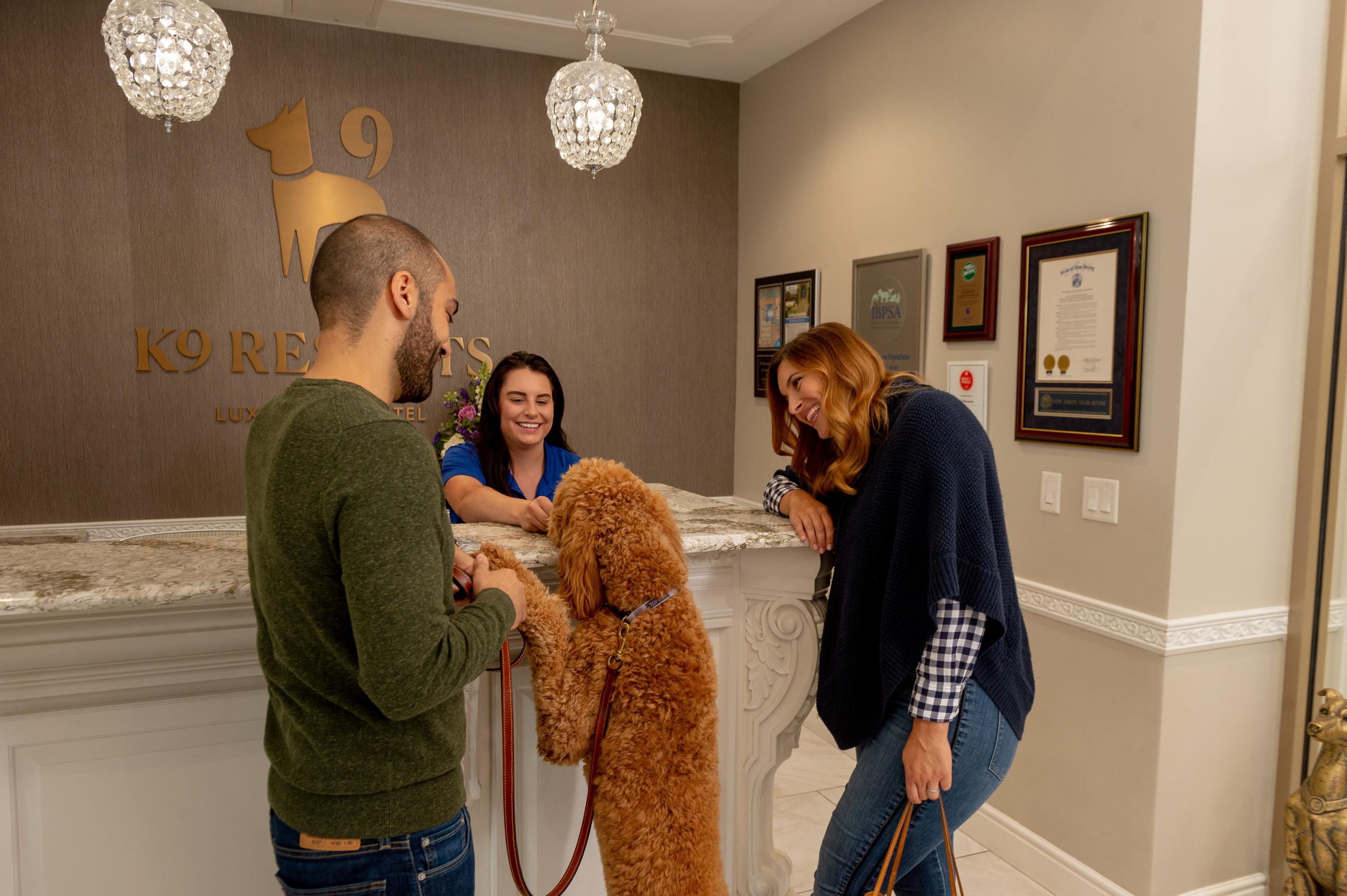 Dog and owners standing at K9 Resorts front desk