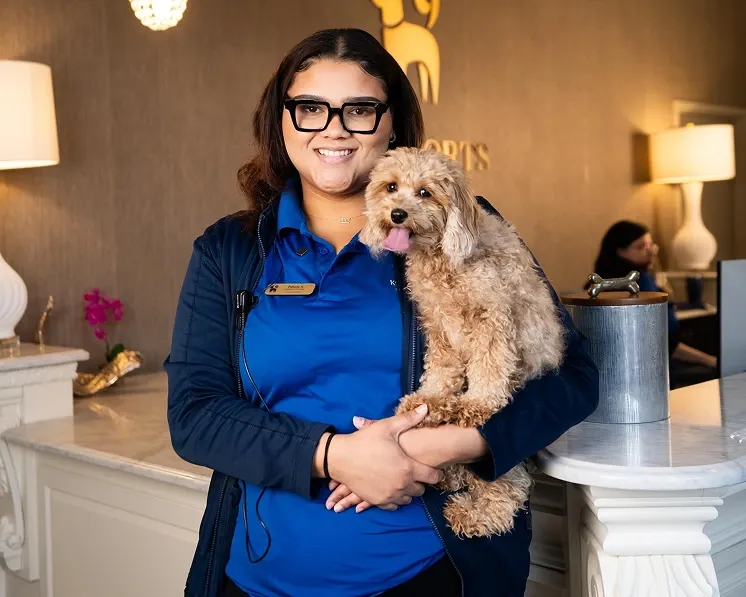 Woman holding small dog smiling at camera